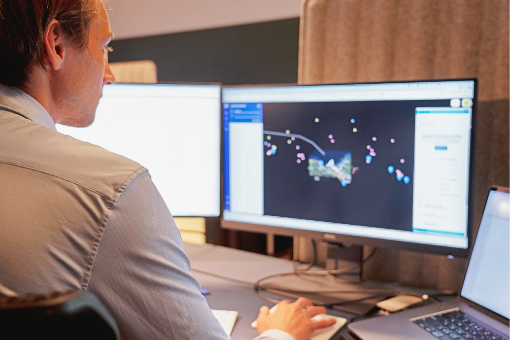 A Maritime Optima employee sitting and working at his desk.